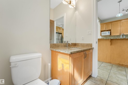 Vanity with granite-style countertop, wood-finish cabinetry, and stainless steel faucet - 10234 155 Street Nw, Edmonton, AB - Indoor Photo Showing Bathroom