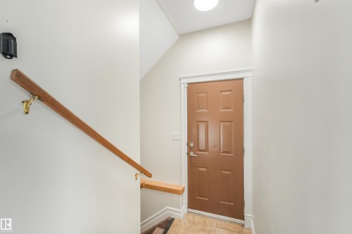 Panel door with a hardware finish, tile flooring, and a ceiling-mounted light fixture - 10234 155 Street Nw, Edmonton, AB - Indoor Photo Showing Other Room