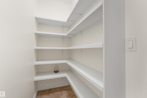 Built-in white shelving system with multiple tiers and tile flooring - 10234 155 Street Nw, Edmonton, AB - Indoor With Storage