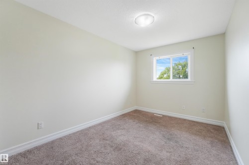 Neutral-toned wall finish, carpeted flooring, window with white trim, and a ceiling-mounted light fixture - 10234 155 Street Nw, Edmonton, AB - Indoor Photo Showing Other Room