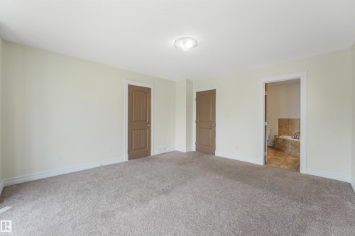 Spacious multi-purpose room with neutral wall finishes, recessed ceiling lighting, and multiple wood-finish doors providing flexible layout options - 10234 155 Street Nw, Edmonton, AB - Indoor Photo Showing Other Room