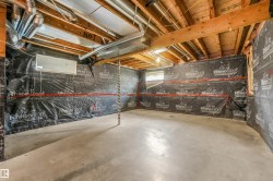 Unfinished basement featuring exposed wood joists, concrete flooring, and visible ductwork - 