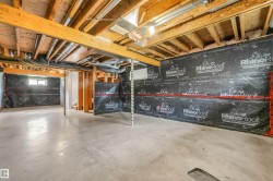 Unfinished basement with concrete flooring, exposed wood ceiling joists, and a small window - 