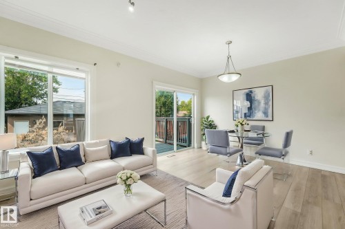 Spacious living area featuring light wood-finish flooring, crown molding, and recessed lighting - 10234 155 Street Nw, Edmonton, AB - Indoor Photo Showing Living Room