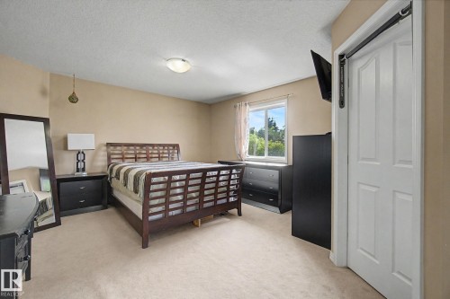 Neutral paint palette, flush mount ceiling light, and window with natural light - 9935 155 Street Nw, Edmonton, AB - Indoor Photo Showing Bedroom