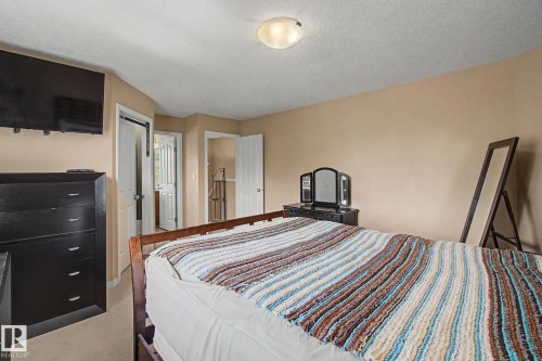 Recessed lighting fixture illuminating a neutral-toned room with white trim and a wood-finish bed frame - 9935 155 Street Nw, Edmonton, AB - Indoor Photo Showing Bedroom