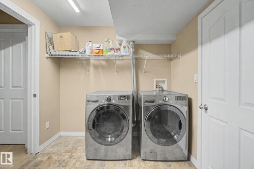 Functional laundry area featuring a wire shelf, tile-look flooring, and neutral wall paint - 9935 155 Street Nw, Edmonton, AB - Indoor Photo Showing Laundry Room