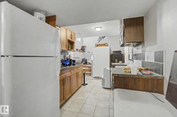 Tile flooring with wood-finish cabinetry and a tiled backsplash - 