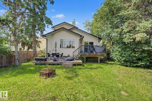 Rear exterior with a wood deck, black metal railings, and a walk-out door - 9935 155 Street Nw, Edmonton, AB - Outdoor With Deck Patio Veranda