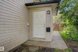 Light-colored siding exterior with a paneled entry door and exterior wall sconce - 