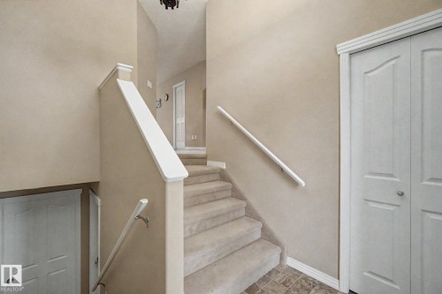 Carpeted staircase with white handrails, white interior doors, and neutral wall tones - 9935 155 Street Nw, Edmonton, AB - Indoor Photo Showing Other Room