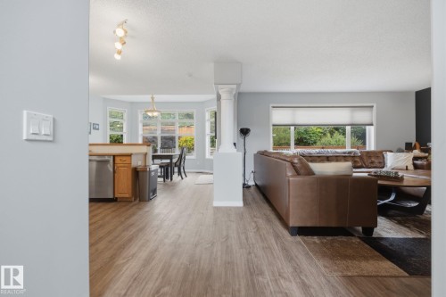 Wood-finish flooring throughout, bay windows, and a decorative column - 15 Orchid Place, St. Albert, AB - Indoor Photo Showing Living Room