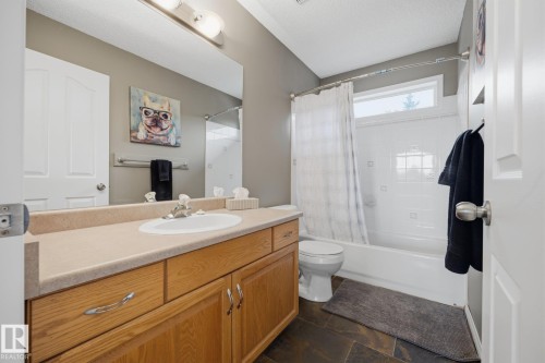 Wood-finish vanity with a light-toned countertop and integrated sink - 15 Orchid Place, St. Albert, AB - Indoor Photo Showing Bathroom