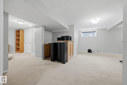 Carpeted flooring, recessed window, built-in wooden shelving, and built-in wooden cabinetry with a sink - 15 Orchid Place, St. Albert, AB - Indoor