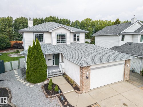 Two-story residence featuring light gray siding, multi-pane windows, and a front porch with white railings - 15 Orchid Place, St. Albert, AB - Outdoor