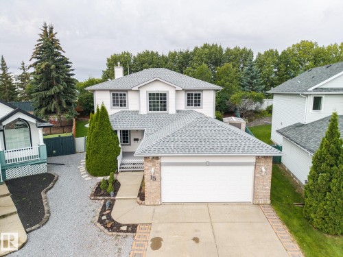 Two-story home featuring a front-facing attached garage, light-colored siding, and a gabled roof - 15 Orchid Place, St. Albert, AB - Outdoor