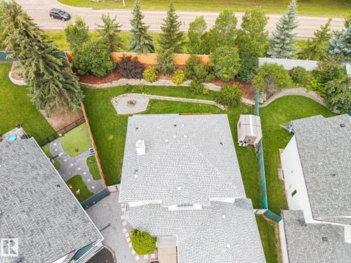 Expansive backyard featuring a large lawn, mature trees, and a fire pit area - 15 Orchid Place, St. Albert, AB - Outdoor