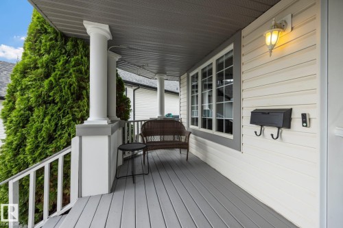 Covered porch with gray decking, white columns, and perimeter railing - 15 Orchid Place, St. Albert, AB - Outdoor With Deck Patio Veranda With Exterior