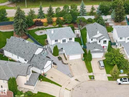 Gabled roofline with light gray shingles, integrated double-car garage, concrete driveway, and mature landscaping - 15 Orchid Place, St. Albert, AB - Outdoor With View