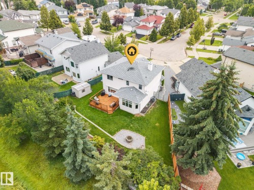 Expansive backyard featuring a manicured lawn, established trees, and a multi-level wood deck - 15 Orchid Place, St. Albert, AB - Outdoor With View