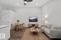Open-concept living space featuring wood-finish flooring, high ceilings, and recessed lighting - 