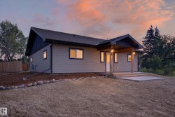 Contemporary single-story residence featuring light gray siding with dark trim accents - 