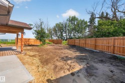 Expansive backyard space featuring a new wood privacy fence, a covered wooden deck, and a concrete patio - 