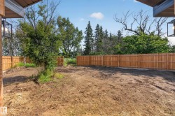 Unfinished backyard space featuring a newly installed privacy fence, existing mature trees, and a clear sky backdrop - 