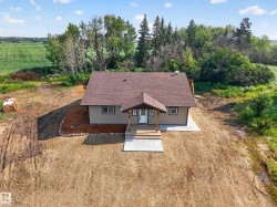 Single-story home featuring a covered front entry with wood posts, a brown shingle roof, light-colored siding, and a concrete pathway - 