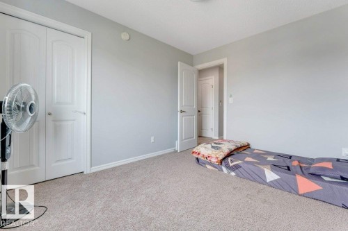 Carpeted room with light gray walls, white trim, and white interior doors - 2436 18 Avenue Nw, Edmonton, AB 