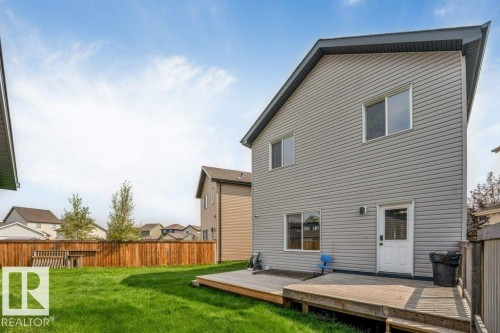 Expansive backyard featuring a manicured lawn, a wooden fence, and a multi-level wooden deck - 2436 18 Avenue Nw, Edmonton, AB 