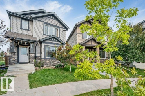 Two-story exterior with siding and stone accents, covered front entry, and a concrete pathway - 2436 18 Avenue Nw, Edmonton, AB 