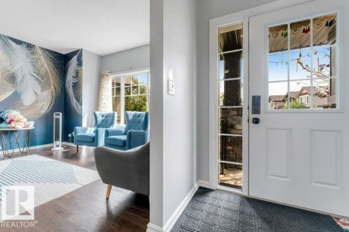 Entry door with sidelight, dark wood-finish flooring, and large window - 2436 18 Avenue Nw, Edmonton, AB 