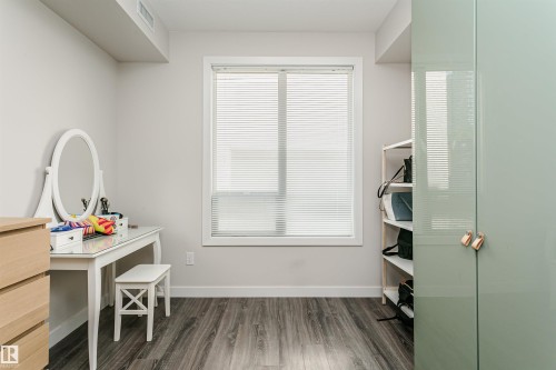 Room featuring wood-finish flooring and light gray wall paint - #208 9907 91 Av Nw, Edmonton, AB - Indoor