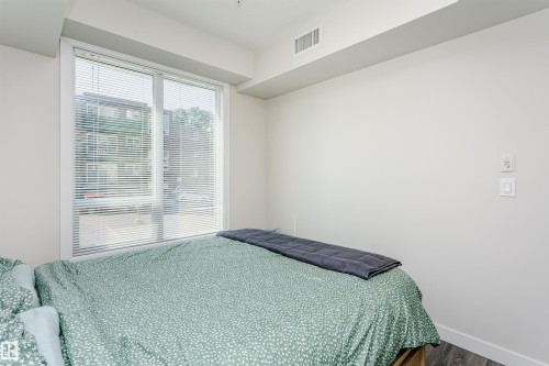 Expansive window with horizontal blinds - #208 9907 91 Av Nw, Edmonton, AB - Indoor Photo Showing Bedroom