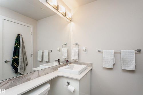 Contemporary bathroom featuring a rectangular vessel sink, white countertop, and integrated vanity storage - #208 9907 91 Av Nw, Edmonton, AB - Indoor Photo Showing Bathroom