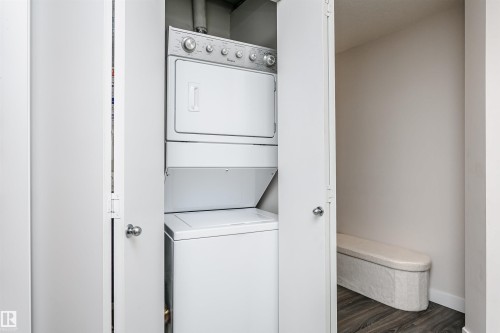 Dedicated laundry closet featuring a stackable washer and dryer unit - #208 9907 91 Av Nw, Edmonton, AB - Indoor Photo Showing Laundry Room