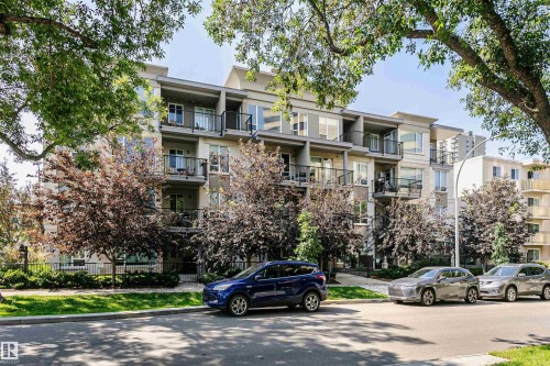 Multi-story residential building featuring a light-colored facade with balconies and numerous windows - #208 9907 91 Av Nw, Edmonton, AB - Outdoor With Balcony