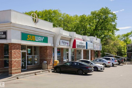 Commercial storefronts featuring brick facades and white overhead signage elements - #208 9907 91 Av Nw, Edmonton, AB - Outdoor