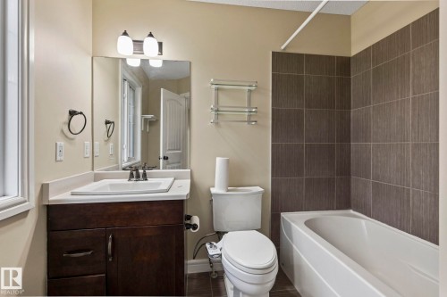 Dark wood-finish vanity with a white countertop and integrated sink - 1209 30 Avenue Nw, Edmonton, AB - Indoor Photo Showing Bathroom