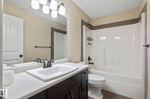 Vanity with integrated sink, dark wood-finish cabinetry, and brushed nickel fixtures - 1209 30 Avenue Nw, Edmonton, AB - Indoor Photo Showing Bathroom