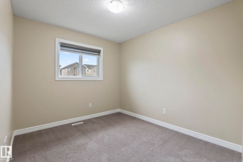 Neutral-toned walls, gray carpeting, and a single window with a roller shade - 1209 30 Avenue Nw, Edmonton, AB - Indoor Photo Showing Other Room