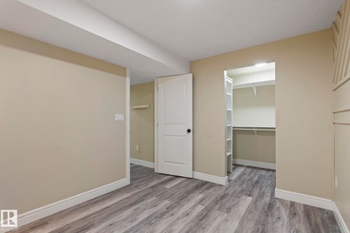 Wood-finish flooring throughout, neutral painted walls, white trim, recessed lighting, and built-in closet shelving - 1209 30 Avenue Nw, Edmonton, AB - Indoor Photo Showing Other Room