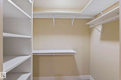 Walk-in closet with built-in shelving, hanging rods, and light-toned walls - 1209 30 Avenue Nw, Edmonton, AB - Indoor With Storage