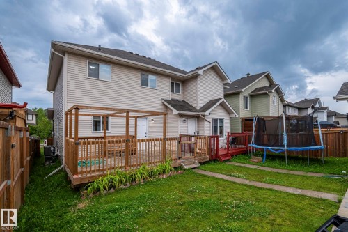 Expansive backyard featuring a manicured lawn, a large wood deck with a pergola, and a smaller red-stained wood deck - 1209 30 Avenue Nw, Edmonton, AB - Outdoor With Deck Patio Veranda