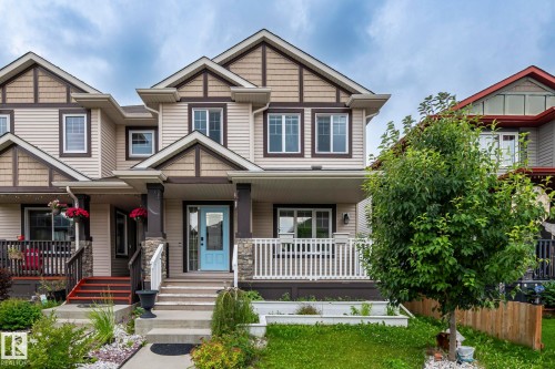 Two-story exterior with light beige siding and brown trim accents - 1209 30 Avenue Nw, Edmonton, AB - Outdoor With Deck Patio Veranda With Facade