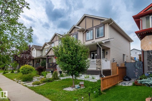 Two-story residence featuring horizontal siding, gable rooflines, and a stone-clad porch column - 1209 30 Avenue Nw, Edmonton, AB - Outdoor