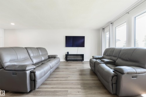 White walls, wood-finish flooring, recessed ceiling lighting, and multiple large windows - 4614 53 Ave, Calmar, AB - Indoor Photo Showing Living Room With Fireplace