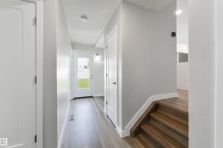 Wood-finish flooring throughout, white interior doors, and a full-light rear door - 