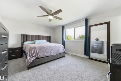 Recessed lighting, ceiling fan with integrated lighting, large window, and light gray carpeting - 4614 53 Ave, Calmar, AB - Indoor Photo Showing Bedroom